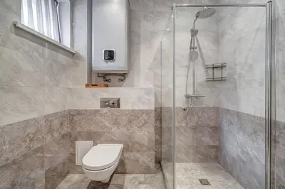 a bathroom with a toilet and a glass shower at Domillion New Old Town Amber 1bdr Z1B4 in Vilnius