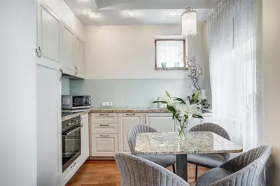 a white kitchen with a table and chairs at Domillion New Old Town Amber 1bdr Z1B4 in Vilnius