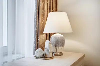 a lamp on a table next to a window at Domillion New Old Town Amber 1bdr Z1B4 in Vilnius