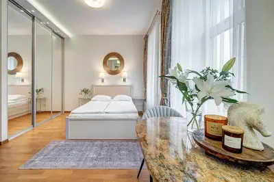 a bedroom with a bed and a table with a glass table sidx sidx at Domillion New Old Town Amber studio Z1B3 in Vilnius
