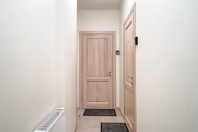 a hallway with a wooden door and a floor at Domillion New Old Town Amber studio Z1B3 in Vilnius