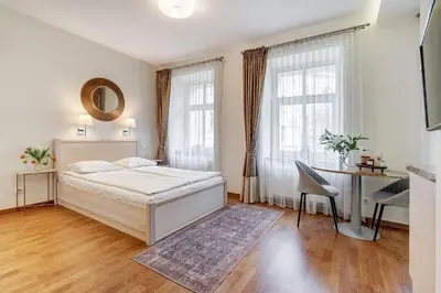 a bedroom with a bed and a desk and windows at Domillion New Old Town Amber studio Z1B3 in Vilnius