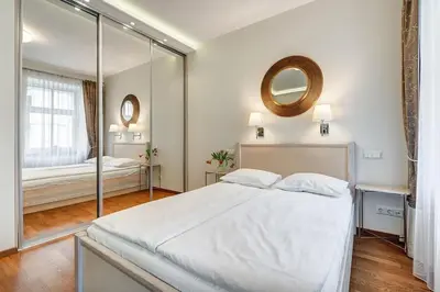 a bedroom with a large white bed and a mirror at Domillion New Old Town Amber studio Z1B3 in Vilnius