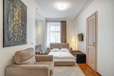 a living room with a couch and a chair at Zemaitijos Versatile 12ppl Triplex in Vilnius