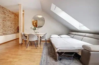 a room with a bed and a table and a couch at Zemaitijos Versatile 12ppl Triplex in Vilnius