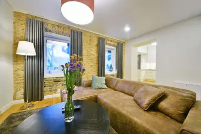 a living room with a brown couch and a table at Domillion old town duplex 14ppl free parking L4D in Vilnius