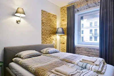 a bedroom with a bed with pillows and a window at Domillion old town duplex 14ppl free parking L4D in Vilnius