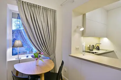 a kitchen with a table with a vase of flowers on it at Domillion old town duplex 14ppl free parking L4D in Vilnius