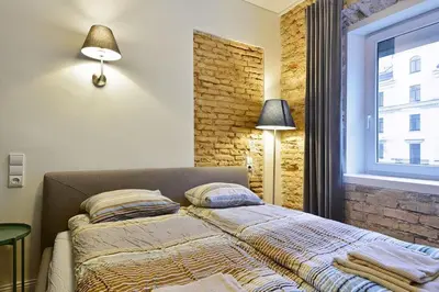 a bedroom with a bed and a brick wall at Domillion old town duplex 14ppl free parking L4D in Vilnius