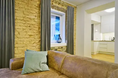 a couch in a living room with a brick wall at Domillion old town duplex 14ppl free parking L4D in Vilnius