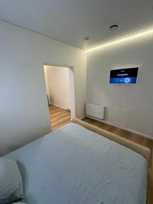 a bedroom with a bed with a tv on the wall at 13 New Airport Apartment in VNO