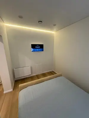 a bedroom with a bed and a tv on the wall at 13 New Airport Apartment in VNO