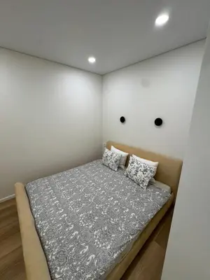 a bed in a room with a wall with two pillows at 13 New Airport Apartment in VNO