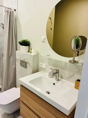 a bathroom with a sink and a toilet and a mirror at Old Town Riverside Haven in Vilnius