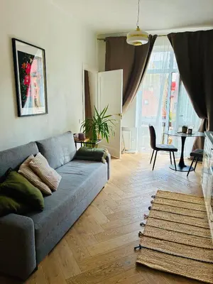 a living room with a blue couch and a table at Old Town Riverside Haven in Vilnius