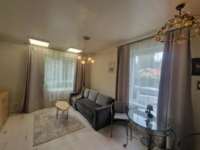 a living room with a couch and a glass table at Vilmos studija in Šiauliai