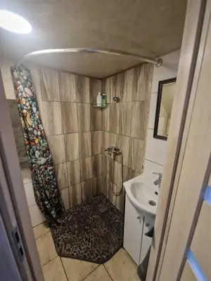 a small bathroom with a shower and a sink at Vilmos studija in Šiauliai