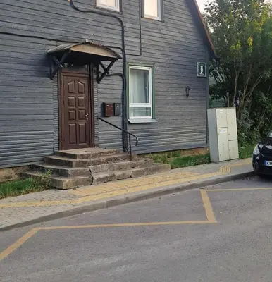 a house with a brown door and stairs in front at Vilmos studija in Šiauliai