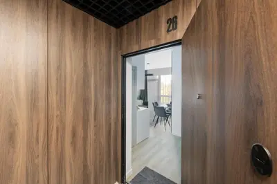 a room with wooden walls and a door with a mirror at Vilnius Central Modern Apartments Vepriai Street in Vilnius