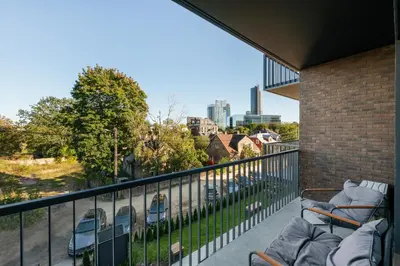 a balcony with chairs and a view of the city at Vilnius Central Modern Apartments Vepriai Street in Vilnius