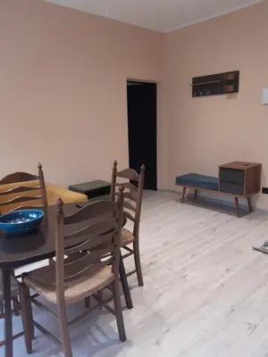 a dining room with a table and chairs and a couch at Vytauto Apartamentai in Biržai