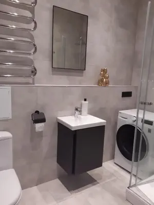 a bathroom with a sink and a washing machine at Vytauto Apartamentai in Biržai