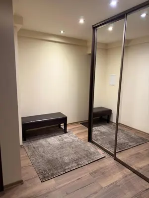 a dressing room with a mirror and a bench at Projektuotojų Apartamentai in Panevėžys