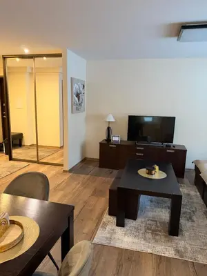 a living room with a table and a tv at Projektuotojų Apartamentai in Panevėžys
