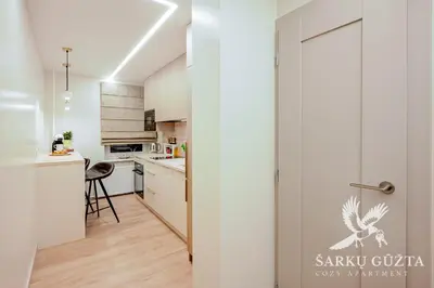 a kitchen with white cabinets and a door with a bird on it at SarkuGuzta Cozy Apartment in Kaunas
