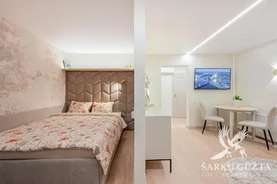a bedroom with a bed and a dining room with a table at SarkuGuzta Cozy Apartment in Kaunas