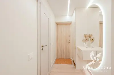 a hallway with a mirror and a white door at SarkuGuzta Cozy Apartment in Kaunas