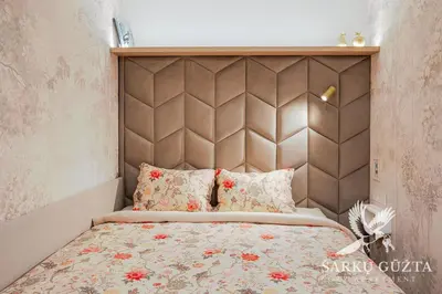 a bed with a padded headboard in a bedroom at SarkuGuzta Cozy Apartment in Kaunas
