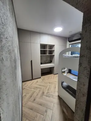 a room with white cabinets and a wooden floor at Marių namai in Kaunas