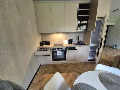 a small kitchen with white cabinets and a stove at Marių namai in Kaunas