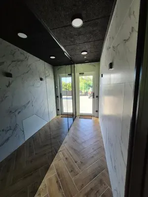 a room with marble walls and a hallway with wooden floors at Marių namai in Kaunas