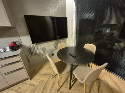 a dining room with a table and chairs and a television at Marių namai in Kaunas