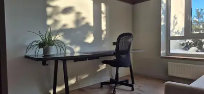 a desk with a chair in a room with a window at Cozy 3-Room Flat by Twinsbet Arena & Ozas in Vilnius