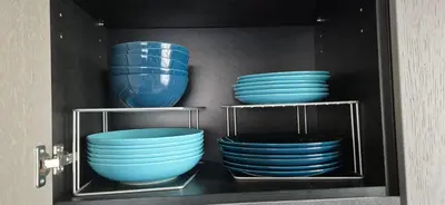 four blue bowls and plates in a cabinet at Cozy 3-Room Flat by Twinsbet Arena & Ozas in Vilnius