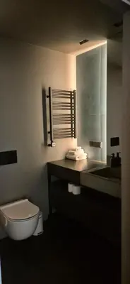 a bathroom with a toilet and a sink and a mirror at Cozy 3-Room Flat by Twinsbet Arena & Ozas in Vilnius