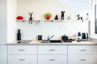 a kitchen with white cabinets and a sink at HYPE Apartments in Kaunas