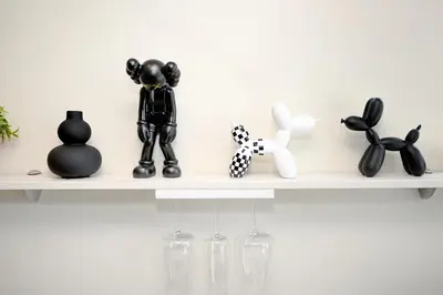 a shelf with black and white sculptures on it at HYPE Apartments in Kaunas