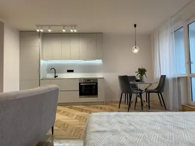 a kitchen and dining room with a table and chairs at Cozy Apartment Near Forest in Kaunas