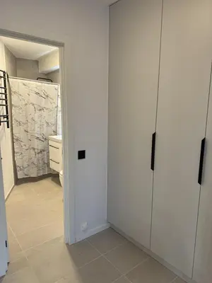 a room with white cabinets and a bathroom with a toilet at Cozy Apartment Near Forest in Kaunas