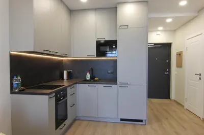 a kitchen with white cabinets and a counter top at Warmzy Home - Modern Flat with Free Parking in Vilnius