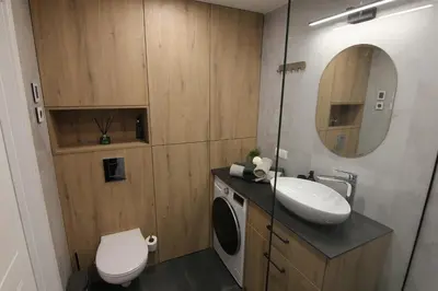 a bathroom with a sink and a toilet and a mirror at Warmzy Home - Modern Flat with Free Parking in Vilnius