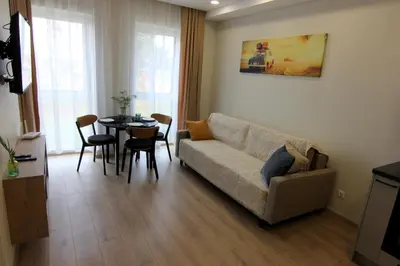 a living room with a couch and a table at Warmzy Home - Modern Flat with Free Parking in Vilnius