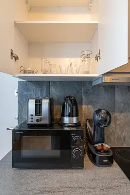 a kitchen with a microwave and a toaster oven at Elegant city center apartment with free parking by Polo Aparments in Kaunas