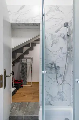 a bathroom with a shower with a glass door at Elegant city center apartment with free parking by Polo Aparments in Kaunas
