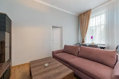a living room with a couch and a table at Elegant city center apartment with free parking by Polo Aparments in Kaunas