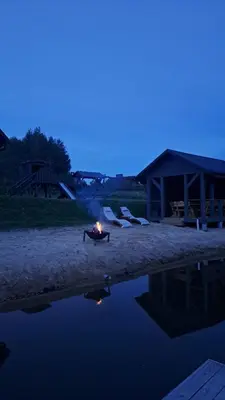 a fire pit sitting on the beach at night at Ūdros slėnis in Bildžiai